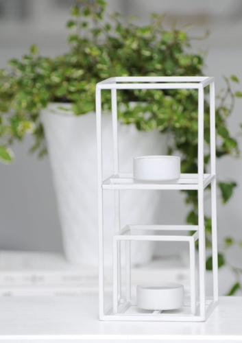 Minimalistyczny biały świecznik w kształcie kostki – elegancki akcent w skandynawskiej aranżacji.