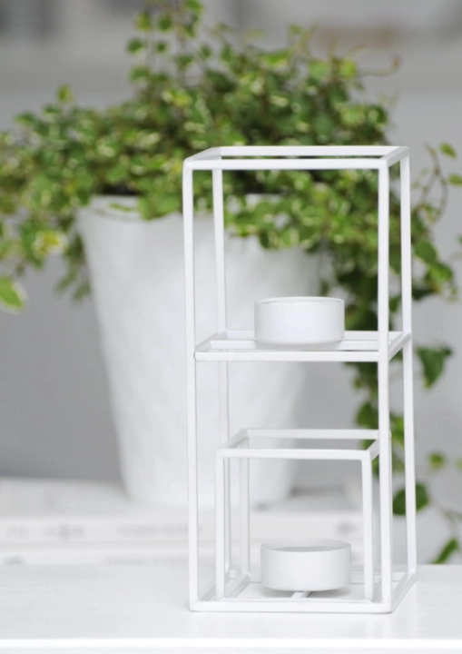 Minimalistyczny biały świecznik w kształcie kostki – elegancki akcent w skandynawskiej aranżacji.