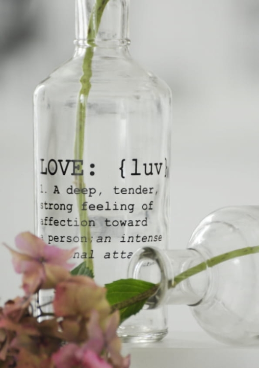 Pojemnik szklany z napisem LOVE – detal grubego szkła i czarnego nadruku na butelce dekoracyjnej