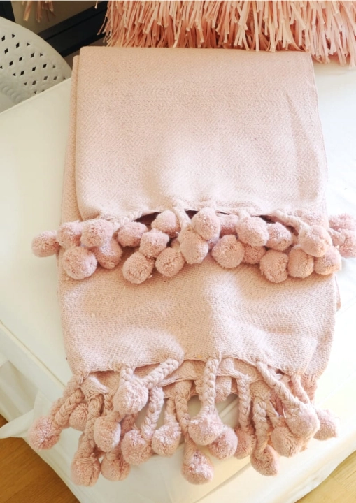 Różowy bawełnaiany pled z pomponami styl boho