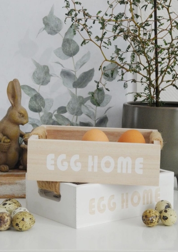 drewniany stojak na jajka z napisem egg home na kuchennym stole
