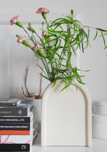 Kremowy ceramiczny wazon w kształcie łuku – hołd dla elegancji art déco - z bukietem goździków