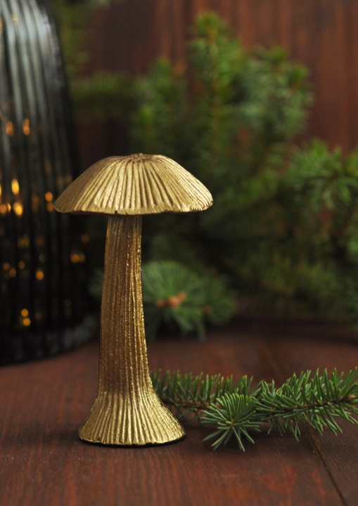 Metalowy złoty grzybek dekoracyjny na świątecznym tle