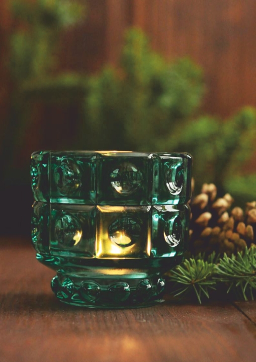 Szklany świecznik w odcieniu turkusu w świątecznej aranżacji z zielenią