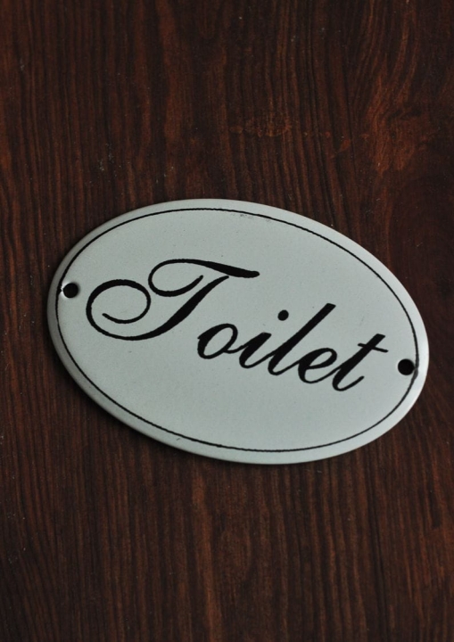 Owalna tabliczka emaliowana na drzwi toalety