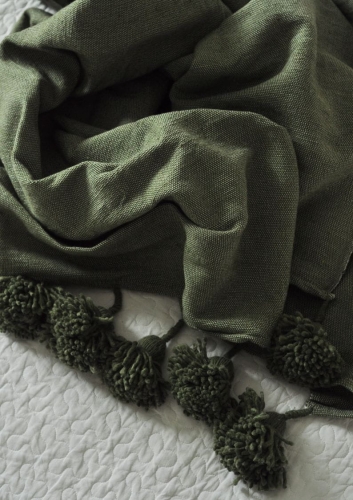 Miękki koc bawełniany Green z ręcznie robionymi pomponami w kolorze szałwiowym.