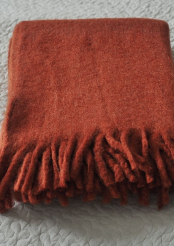 Pled z frędzlami w kolorze rdzawym – ciepły koc z domieszką wełny moherowej.