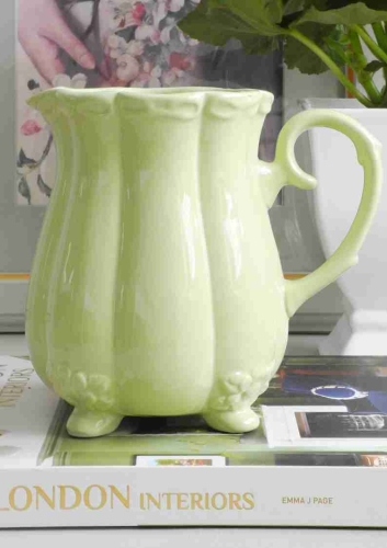 Ceramiczny dzbanek w stylu retro w pistacjowym kolorze na stole
