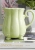 Ceramiczny dzbanek w stylu retro w pistacjowym kolorze na stole