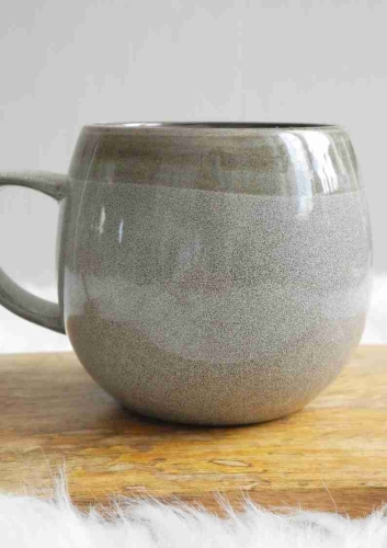 Szary ceramiczny kubek 350ml o obłym kształcie na drewnianym blacie