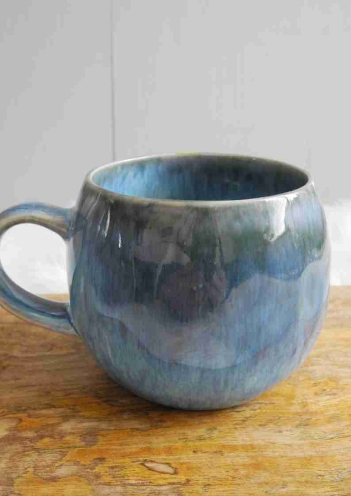 Niebieski ceramiczny kubek 350ml o błyszczącym wykończeniu na tle drewnianej deski