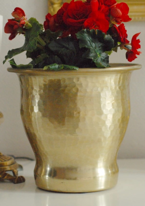 Złota osłonka na kwiaty z młotkowanego metalu, elegancka dekoracja do salonu, naturalne materiały.