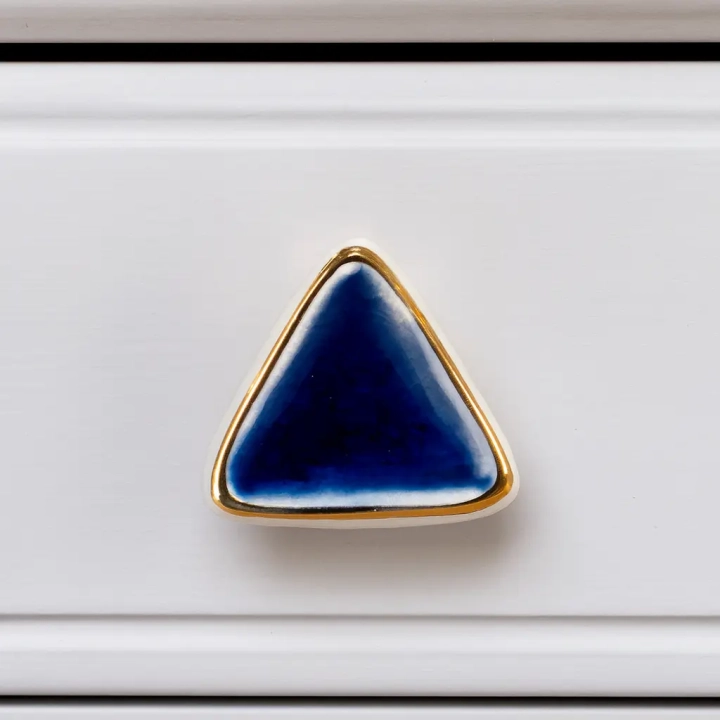 Granatowa gałka ceramiczna trójkątna ze złotą ramką Clayre & Eef na białej szufladzie
