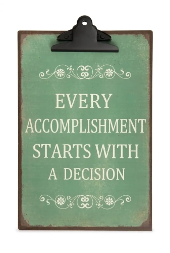 Ciemnozielona, metalowa podkładka z czarnym klipsem w stylu vintage, format A4, z białym ozdobnym tekstem po angielsku: Every accomplishment starts with a decision