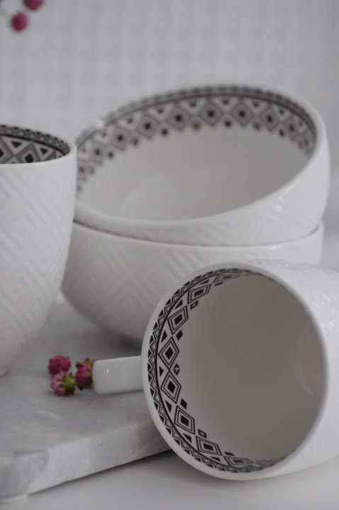 Wnętrze czarno-białego kubka do kawy z czarnym motywem geometrycznym na tle białej porcelany.