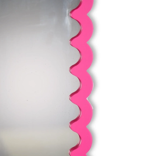 Zbliżenie na nasyconą różową i falistą ramę dekoracyjnego lustra ściennego w stylu dopamine decor