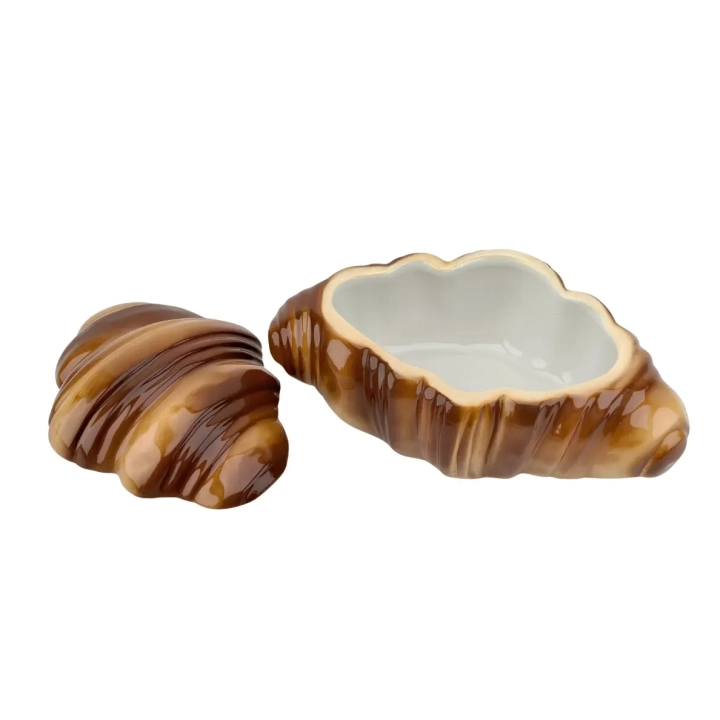 Otwarty brązowy pojemnik ceramiczny w kształcie rogalika ze zdjętą pokrywką leżącą obok