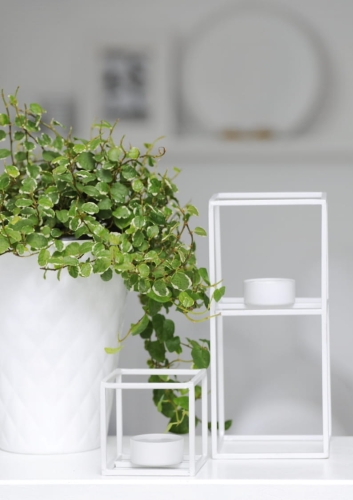 Geometryczny świecznik z białego metalu – elegancka ozdoba stołu, komody lub parapetu.