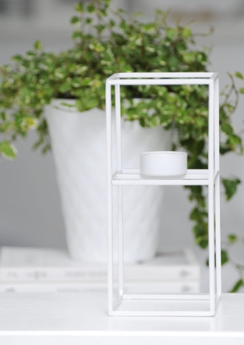 Biały metalowy świecznik w stylu skandynawskim – minimalistyczna dekoracja do nowoczesnych wnętrz.