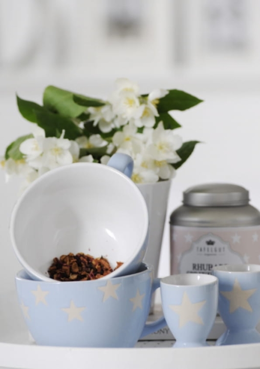 kieliszek na jajko ceramiczny w jasnym odcieniu niebieskiego na stole śniadaniowym